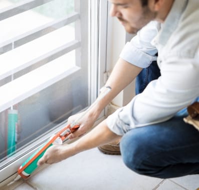 Man applying sealant on doors